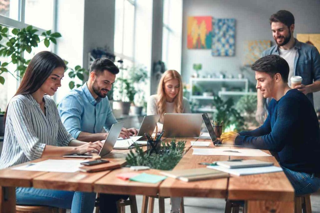 Laissez-Faire Leadership: Build Autonomy-Driven Teams That Thrive Without Micromanagement Team collaborating independently in a modern workspace reflecting laissez-faire leadership and autonomy